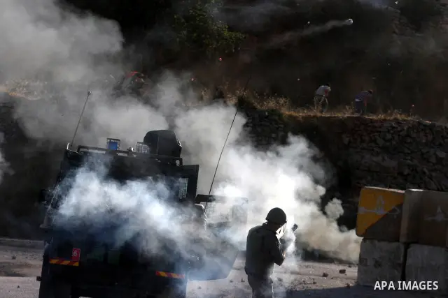 An Israeli soldier shoots tear gas at Palestinian protestors during clashes following a demonstration outside Ofer prison, near the West Bank city of Ramallah, in solidarity with Palestinian prisoners being held in Israe...