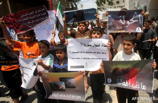 Palestinian children hold a Syrian revolution flag during a protest against Syria's President Bashar al-Assad and in support of Syrian civilians at Nusseirat refugee camp in the central Gaza Strip on June 22, 2012. The F...