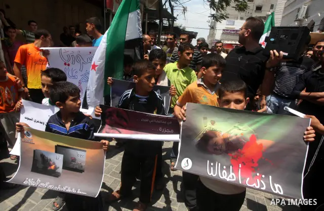 Palestinian children hold a Syrian revolution flag during a protest against Syria's President Bashar al-Assad and in support of Syrian civilians at Nusseirat refugee camp in the central Gaza Strip on June 22, 2012. The F...