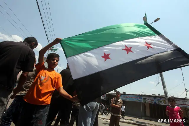 Palestinian children hold a Syrian revolution flag during a protest against Syria's President Bashar al-Assad and in support of Syrian civilians at Nusseirat refugee camp in the central Gaza Strip on June 22, 2012. The F...