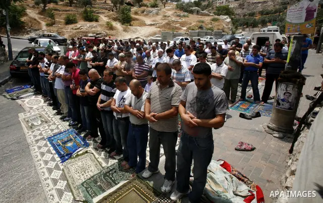 Palestinian Muslim worshippers attend Friday prayers outside a protest tent against the continuing 'Judaization of Jerusalem' by Jewish settlers, in the mostly Arab neighbourhood of Silwan in east Jerusalem on June 22, 2...
