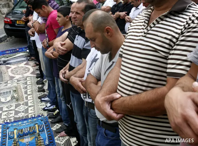 Palestinian Muslim worshippers attend Friday prayers outside a protest tent against the continuing 'Judaization of Jerusalem' by Jewish settlers, in the mostly Arab neighbourhood of Silwan in east Jerusalem on June 22, 2...