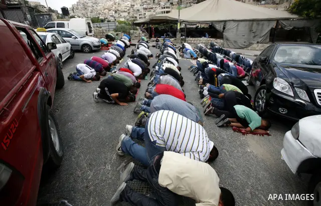 Palestinian Muslim worshippers attend Friday prayers outside a protest tent against the continuing 'Judaization of Jerusalem' by Jewish settlers, in the mostly Arab neighbourhood of Silwan in east Jerusalem on June 22, 2...