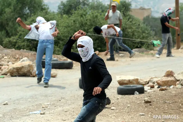 Palestinian demonstrators throw stones during clashes following a weekly protest against the Jewish settlement of Kdumim, near Nablus,in the northern West Bank village of Kufr Qaddum, June 22, 2012. According to medical...