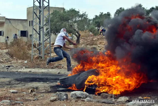 A Palestinian demonstrator throws stones during clashes following a weekly protest against the Jewish settlement of Kdumim, near Nablus,in the northern West Bank village of Kufr Qaddum, June 22, 2012. According to medica...