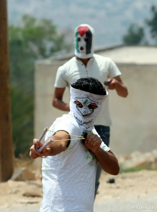 A Palestinian demonstrator throws stones during clashes following a weekly protest against the Jewish settlement of Kdumim, near Nablus,in the northern West Bank village of Kufr Qaddum, June 22, 2012. According to medica...