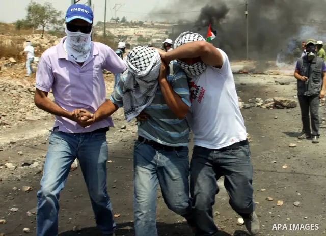 Palestinian protesters help a wounded man during clashes following a weekly protest against the Jewish settlement of Kdumim, near Nablus,in the northern West Bank village of Kufr Qaddum, June 22, 2012. According to medic...