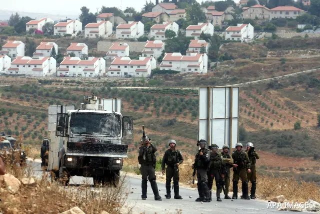 An Israeli soldier loads his weapon during clashes with Palestinian protesters in the West Bank village of Nabi Saleh, near Ramallah, on June 22, 2012, following a demonstration against the confiscation of Palestinian la...