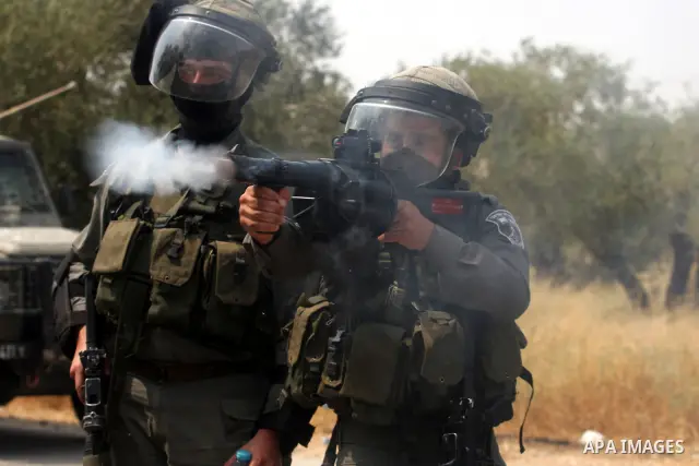 An Israeli soldier fires a tear gas canister during clashes with Palestinian protesters in the West Bank village of Nabi Saleh, near Ramallah, on June 22, 2012, following a demonstration against the confiscation of Pales...