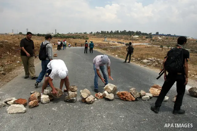 Palestinian protesters set big stones as barricades during clashes with Israeli soldiers in the West Bank village of Nabi Saleh, near Ramallah, on June 22, 2012, following a demonstration against the confiscation of Pale...