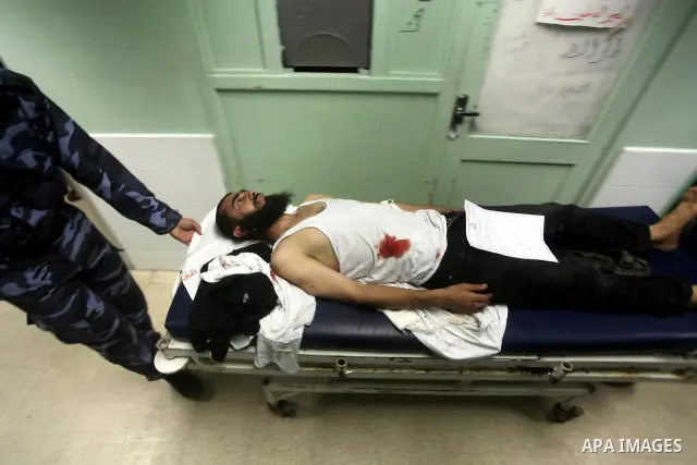 Palestinian medics wheel a wounded man to the treatment room of Al-Aqsa hospital following an Israeli airstrike east of Bureij refugee camp, in Deir Al Balah, central Gaza strip, Friday, June 22, 2012. An Israeli air str...
