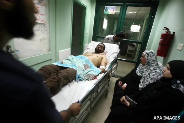Palestinian medics wheel a wounded man to the treatment room of Al-Aqsa hospital following an Israeli airstrike east of Bureij refugee camp, in Deir Al Balah, central Gaza strip, Friday, June 22, 2012. An Israeli air str...