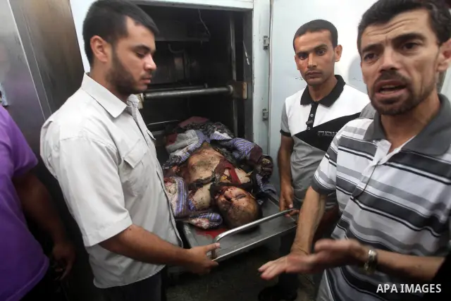Relatives of Palestinian militant Basil Ahmed look at his body at al-Aqsa hospital in Deir Al Balah, central Gaza strip, following an Israeli airstrike east of Bureij refugee camp Friday, June 22, 2012. An Israeli air st...