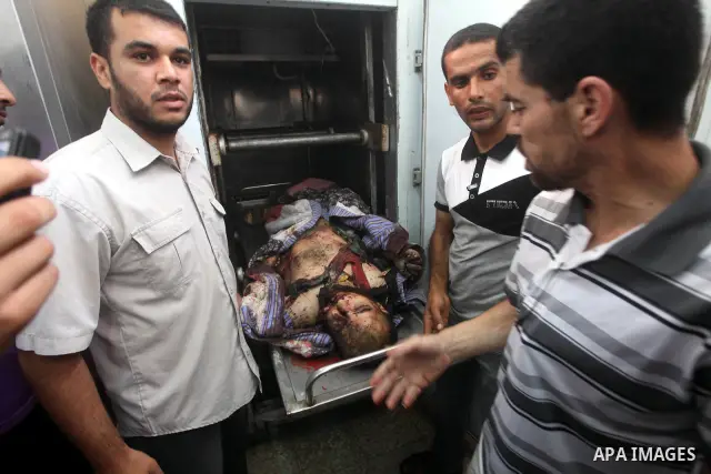 Relatives of Palestinian militant Basil Ahmed look at his body at al-Aqsa hospital in Deir Al Balah, central Gaza strip, following an Israeli airstrike east of Bureij refugee camp Friday, June 22, 2012. An Israeli air st...