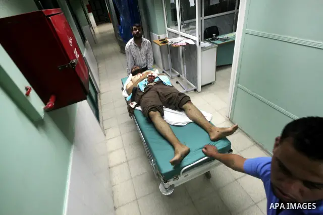 Palestinian medics wheel a wounded man to the treatment room of Al-Aqsa hospital following an Israeli airstrike east of Bureij refugee camp, in Deir Al Balah, central Gaza strip, Friday, June 22, 2012. An Israeli air str...