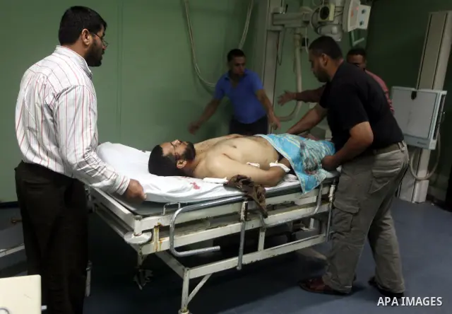 Palestinian medics wheel a wounded man to the treatment room of Al-Aqsa hospital following an Israeli airstrike east of Bureij refugee camp, in Deir Al Balah, central Gaza strip, Friday, June 22, 2012. An Israeli air str...