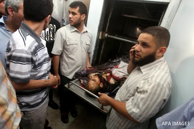 Relatives of Palestinian militant Basil Ahmed look at his body at al-Aqsa hospital in Deir Al Balah, central Gaza strip, following an Israeli airstrike east of Bureij refugee camp Friday, June 22, 2012. An Israeli air st...