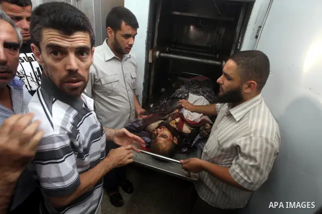 Relatives of Palestinian militant Basil Ahmed look at his body at al-Aqsa hospital in Deir Al Balah, central Gaza strip, following an Israeli airstrike east of Bureij refugee camp Friday, June 22, 2012. An Israeli air st...