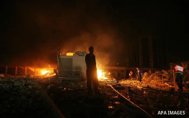Hamas Police and firemen look at the damages and try to put out a fire at the al-Saraya Security complex following an Israeli air strike on Gaza on June 23, 2012. Israel launched more air strikes against on the Gaza Stri...