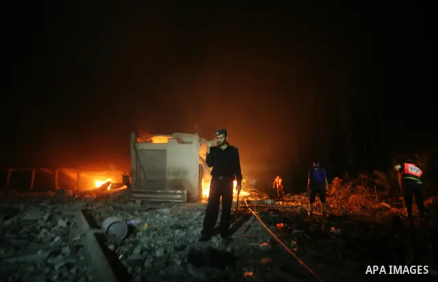 Hamas Police and firemen look at the damages and try to put out a fire at the al-Saraya Security complex following an Israeli air strike on Gaza on June 23, 2012. Israel launched more air strikes against on the Gaza Stri...