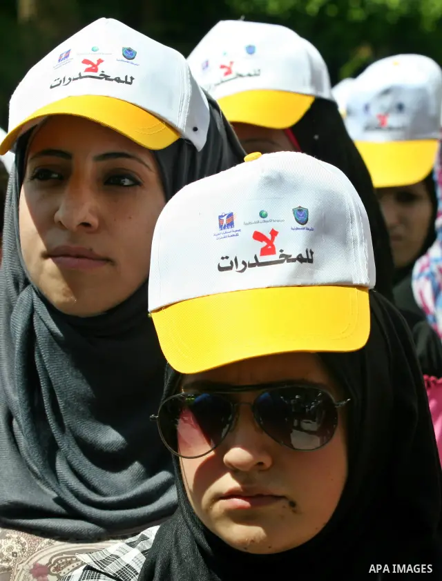 Palestinians wearing hats with the slogan " no for drugs" march in the streets of the West Bank city of Nablus on June 23, 2012 as part of an awareness campaign, entitled "fighting drug", against the consumption of narco...