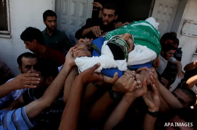 Palestinians carry the body of Hamas militant Hamam Abu Qadus during his funeral in Gaza City June 23, 2012. Israel launched air raids early on Saturday against three Hamas security targets in the Gaza Strip, wounding at...