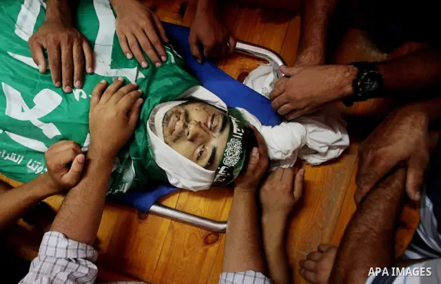 Palestinians carry the body of Hamas militant Hamam Abu Qadus during his funeral in Gaza City June 23, 2012. Israel launched air raids early on Saturday against three Hamas security targets in the Gaza Strip, wounding at...