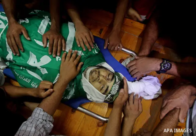 Palestinians carry the body of Hamas militant Hamam Abu Qadus during his funeral in Gaza City June 23, 2012. Israel launched air raids early on Saturday against three Hamas security targets in the Gaza Strip, wounding at...