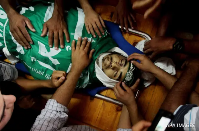 Palestinians carry the body of Hamas militant Hamam Abu Qadus during his funeral in Gaza City June 23, 2012. Israel launched air raids early on Saturday against three Hamas security targets in the Gaza Strip, wounding at...