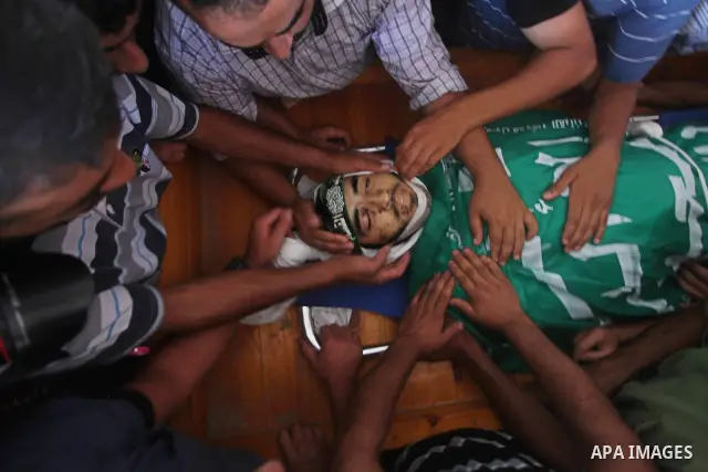Palestinians carry the body of Hamas militant Hamam Abu Qadus during his funeral in Gaza City June 23, 2012. Israel launched air raids early on Saturday against three Hamas security targets in the Gaza Strip, wounding at...