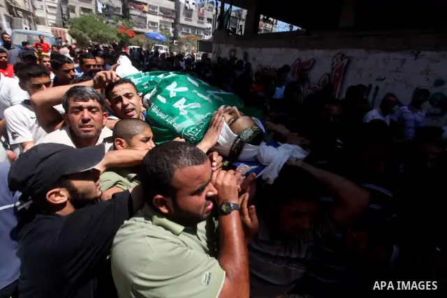 Palestinians carry the body of Hamas militant Hamam Abu Qadus during his funeral in Gaza City June 23, 2012. Israel launched air raids early on Saturday against three Hamas security targets in the Gaza Strip, wounding at...
