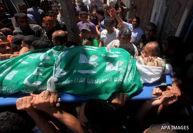 Palestinians carry the body of Hamas militant Hamam Abu Qadus during his funeral in Gaza City June 23, 2012. Israel launched air raids early on Saturday against three Hamas security targets in the Gaza Strip, wounding at...