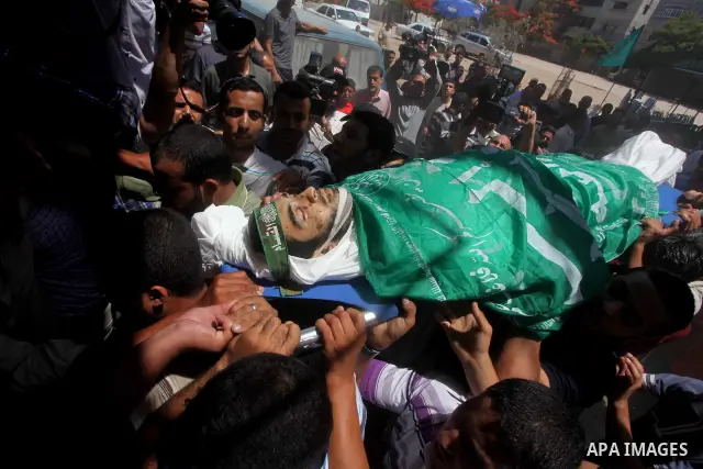Palestinians carry the body of Hamas militant Hamam Abu Qadus during his funeral in Gaza City June 23, 2012. Israel launched air raids early on Saturday against three Hamas security targets in the Gaza Strip, wounding at...