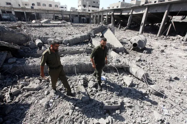 Palestinian Hamas security personnel inspect the damage at al-Saraya Security complex in the centre of Gaza City on June 23, 2012 as Israel launched fresh air strikes on the Gaza Strip overnight after killing two people...