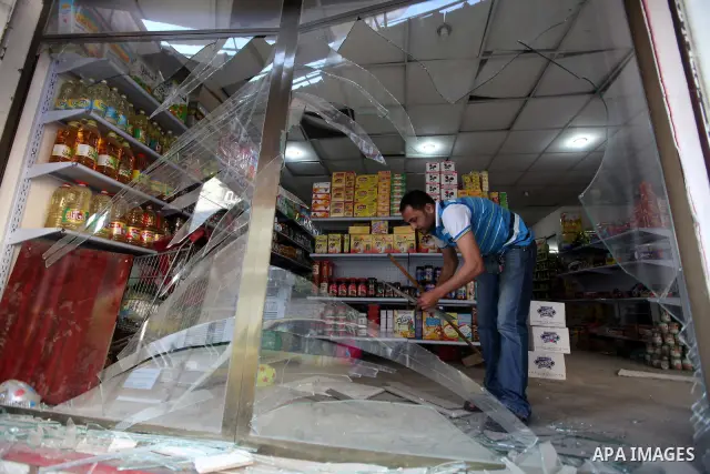 A Palestinian man inspects the damage in his shop near al-Saraya Security complex in the centre of Gaza City on June 23, 2012 as Israel launched fresh air strikes on the Gaza Strip overnight after killing two people in e...