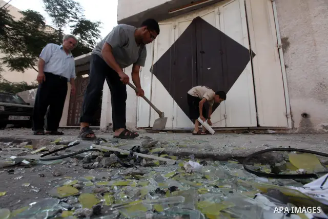 Palestinians inspect the damage in his shop near al-Saraya Security complex in the centre of Gaza City on June 23, 2012 as Israel launched fresh air strikes on the Gaza Strip overnight after killing two people in earlier...