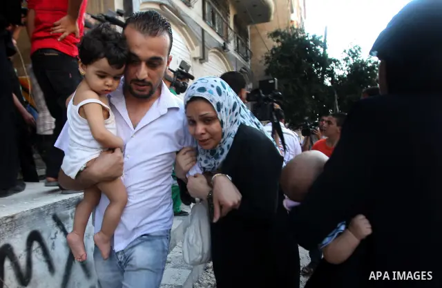 Palestinian families fleeing from the place of the bombing scared following an Israeli strike on Gaza City on June 23, 2012. A Palestinian teenager riding a motorcycle was killed and 10 passers-by wounded in a fresh Isra...