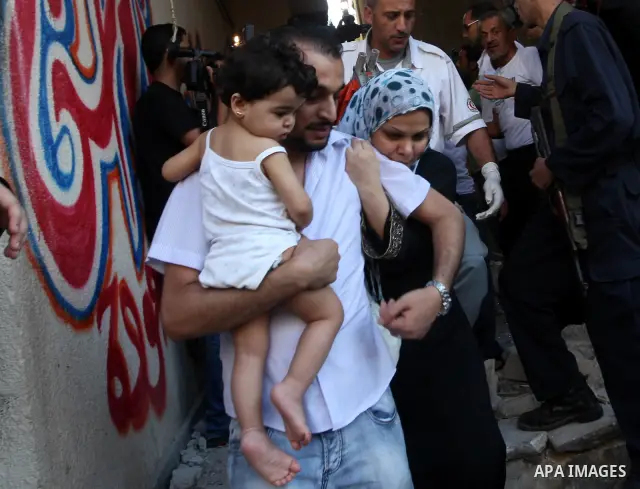 Palestinian families fleeing from the place of the bombing scared following an Israeli strike on Gaza City on June 23, 2012. A Palestinian teenager riding a motorcycle was killed and 10 passers-by wounded in a fresh Isra...