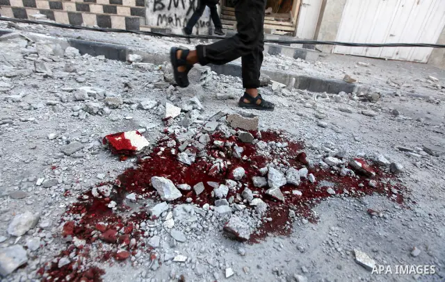 Palestinian children stand looking at the blood stained street following an Israeli strike on Gaza City on June 23, 2012. A Palestinian teenager riding a motorcycle was killed and 10 passers-by wounded in a fresh Israeli...