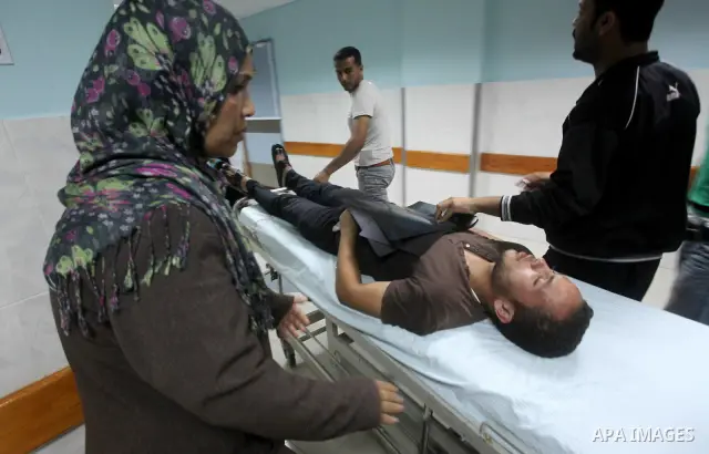 Palestinians wheel a wounded man at a hospital in Gaza City, following an Israeli air strike June 23, 2012. Israeli air strikes on Hamas security targets in Gaza killed two Palestinians and wounded 30 people on Saturday,...