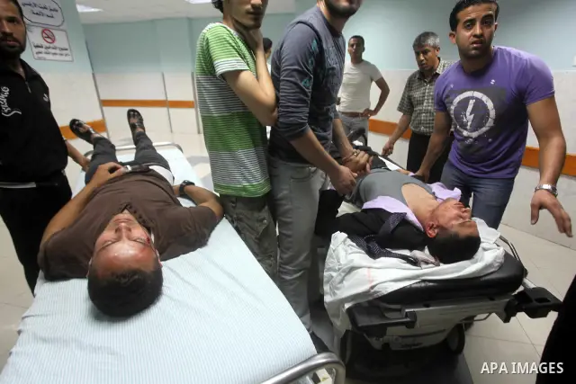 Palestinians wheel a wounded man at a hospital in Gaza City, following an Israeli air strike June 23, 2012. Israeli air strikes on Hamas security targets in Gaza killed two Palestinians and wounded 30 people on Saturday,...