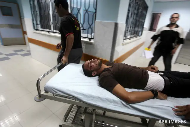 Palestinians wheel a wounded man at a hospital in Gaza City, following an Israeli air strike June 23, 2012. Israeli air strikes on Hamas security targets in Gaza killed two Palestinians and wounded 30 people on Saturday,...