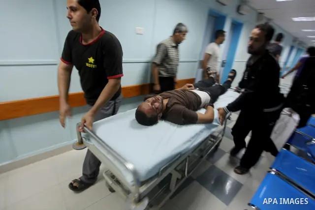 Palestinians wheel a wounded man at a hospital in Gaza City, following an Israeli air strike June 23, 2012. Israeli air strikes on Hamas security targets in Gaza killed two Palestinians and wounded 30 people on Saturday,...