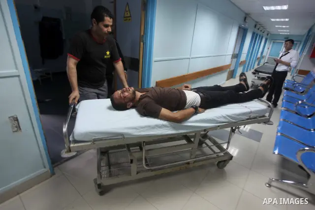 Palestinians wheel a wounded man at a hospital in Gaza City, following an Israeli air strike June 23, 2012. Israeli air strikes on Hamas security targets in Gaza killed two Palestinians and wounded 30 people on Saturday,...
