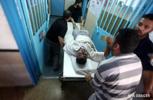 Palestinians wheel a wounded man at a hospital in Gaza City, following an Israeli air strike June 23, 2012. Israeli air strikes on Hamas security targets in Gaza killed two Palestinians and wounded 30 people on Saturday,...