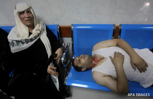 A Palestinian woman and man sit wounded in the emergency room of a hospital following an Israeli strike on Gaza City on June 23, 2012. A Palestinian teenager riding a motorcycle was killed, and 10 passers-by wounded in a...