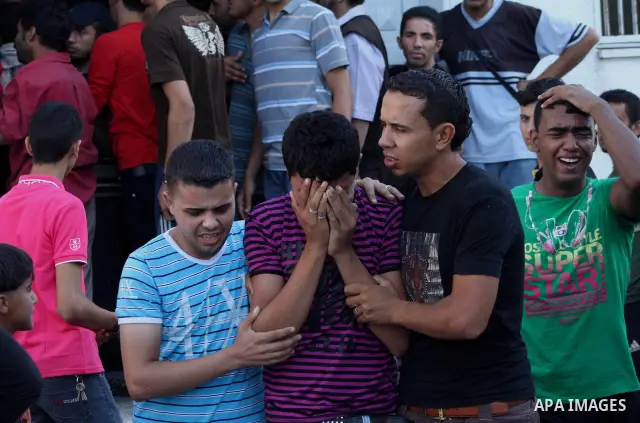 Palestinian relatives of Osama Ali grieves at the morgue after the teenager was killed in an Israeli strike on Gaza City on June 23, 2012. The Palestinian teenager riding a motorcycle was killed, and 10 passers-by wounde...