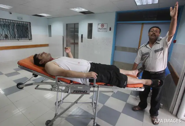 A Palestinian medic wheels a wounded man at a hospital in Gaza City, following an Israeli air strike June 23, 2012. Israeli air strikes on Hamas security targets in Gaza killed two Palestinians and wounded 30 people on S...