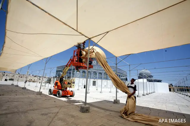 Palestinian workers put the sunshades on the Dome of the Rock mosque in preparation for receive the holy month of Ramadan, in Jerusalem's old city on June 24, 2012. Photo by Mahfouz Abu Turk