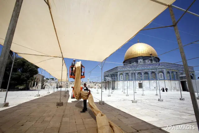 Palestinian workers put the sunshades on the Dome of the Rock mosque in preparation for receive the holy month of Ramadan, in Jerusalem's old city on June 24, 2012. Photo by Mahfouz Abu Turk